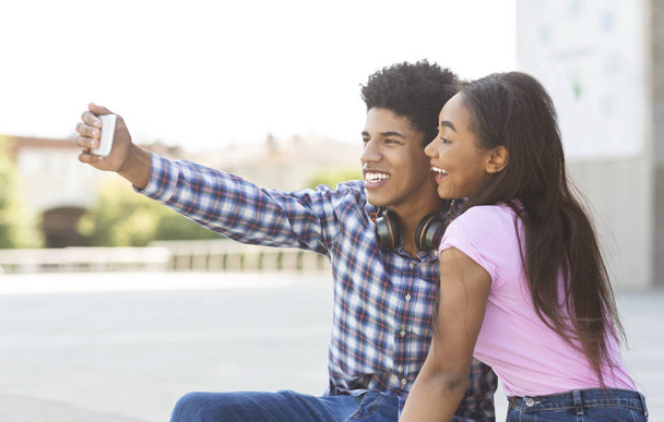 Un selfie de couple. adolescent fille et garçon photographier eux-mêmes sur smartphone
. - Photo, image