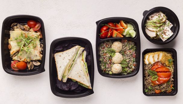 Здоровое питание в черных коробках доставки на обед в офисе на белом
 - Фото, изображение