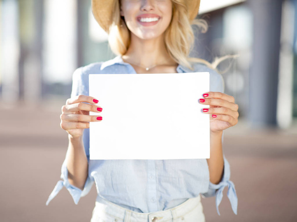 Mujer bonita sosteniendo cartel vacío fuera del aeropuerto
 - Foto, Imagen