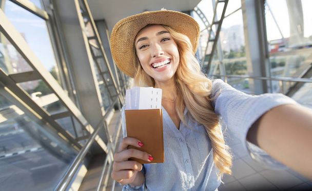 Nauti matkustamisesta. Kaunis nainen ottaa selfie lentokentällä
 - Valokuva, kuva