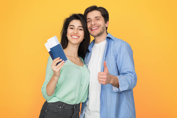 Loving couple ready for travel, showing passport and thumb up - Photo, Image