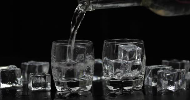 Ömlött két lövés vodka egy üveg pohárba. Fekete háttér - Felvétel, videó