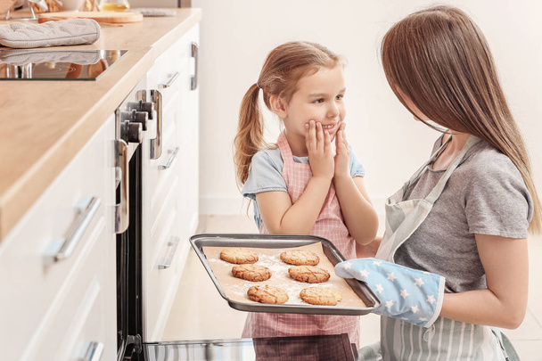Petite fille et sa mère cuisinant des biscuits dans la cuisine
 - Photo, image