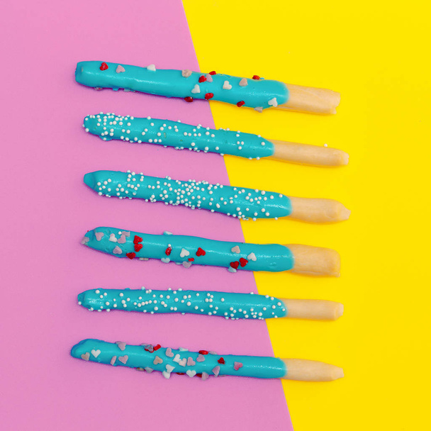 Sweet sticks on colored background. Flat lay food art - Foto, afbeelding