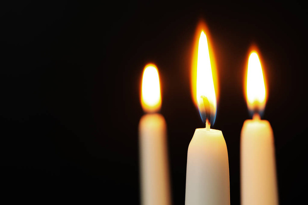Burning candles on dark background, space for text. Symbol of sorrow - Φωτογραφία, εικόνα