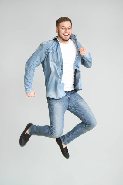 Handsome jumping young man on light background - Foto, immagini