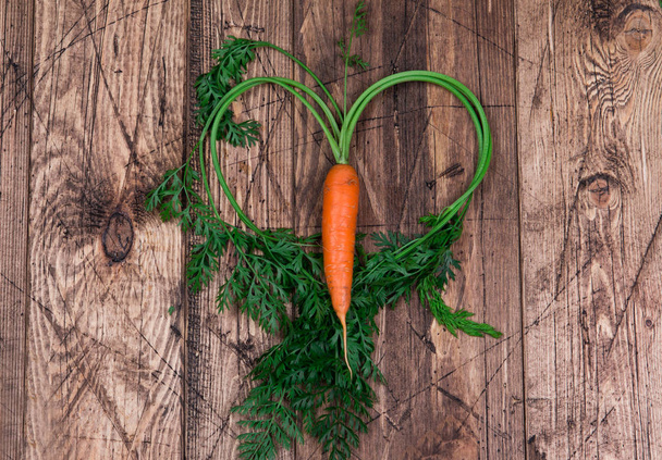 Close up of fresh carrot on rustic wooden background, top view - Foto, immagini