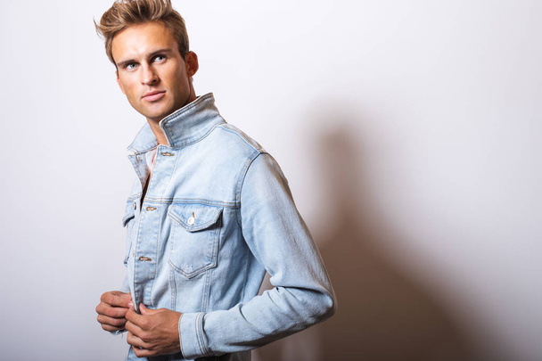 Handsome young man in jeans jacket pose in studio. - Foto, immagini