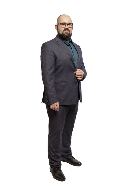 Young bald bearded man with glasses and a full-length suit. Isolated over white background.  - Foto, Bild