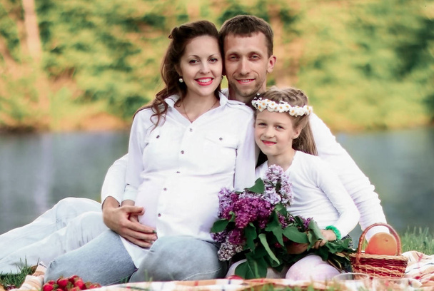 happy father of a daughter and a pregnant mom at a picnic. - Foto, Bild