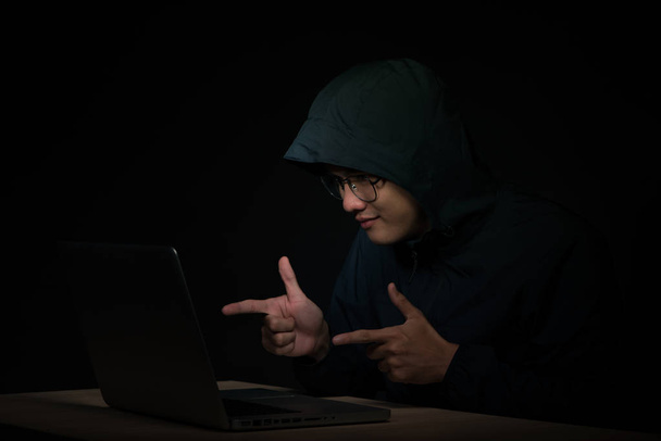 Успешный мужчина-хакер позирует перед ноутбуком, сжимает кулаки, одевается в черную одежду, радуется, заканчивая плохой вирус данных
, - Фото, изображение