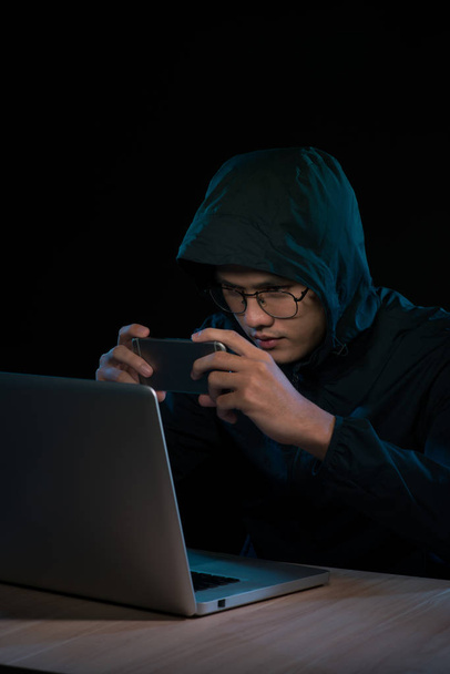 Hacker using a smartphone. Very dark nocturnal environment - Φωτογραφία, εικόνα