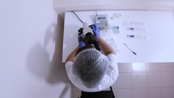 Női Laborasszisztens a munkahelyen felülnézetben - Felvétel, videó