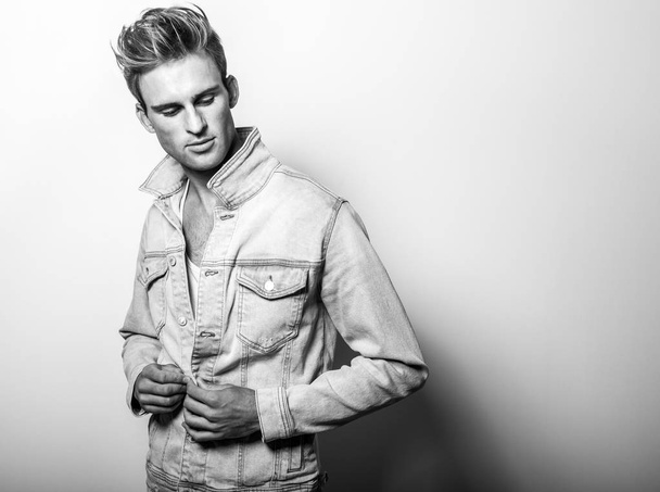 Handsome young man in jeans jacket. Black-white studio portrait. - Fotoğraf, Görsel