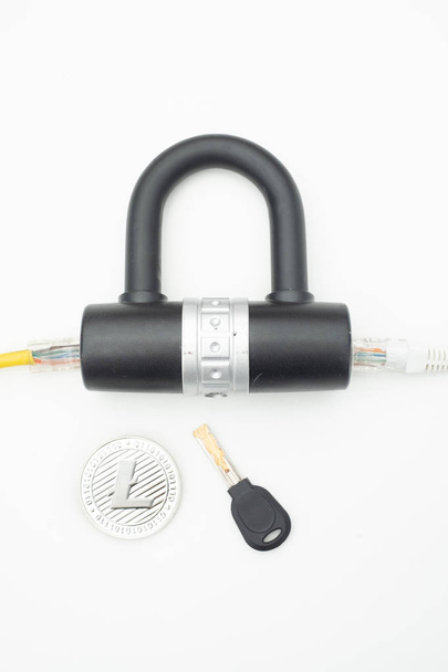 Dos cables de red de computadoras pasando por una cerradura con una llave y una moneda criptográfica
 - Foto, imagen