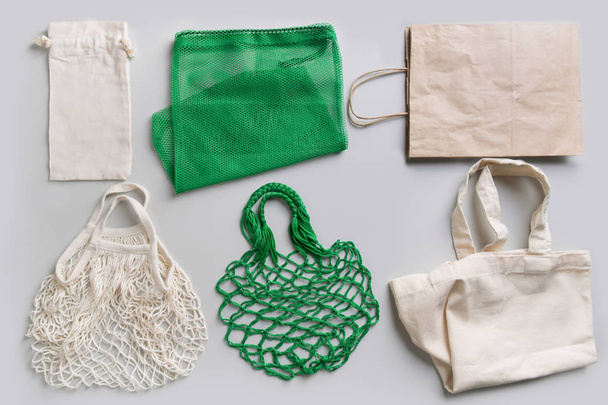 Set of eco friendly reusable shopping bag on grey. Zero waste concept. - 写真・画像
