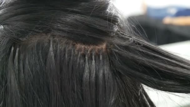 Μακριά όμορφα μαύρα μαλλιά στυλίστας μπούκλες. Χτένισμα και κέρλινγκ. Κάψουλες επέκτασης μαλλιών στο κεφάλι - Πλάνα, βίντεο