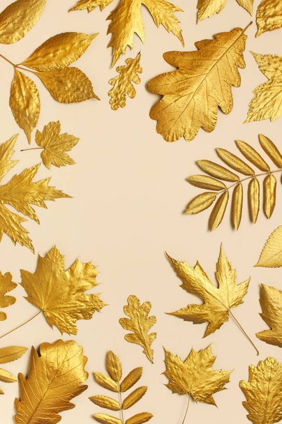 flach lag kreative Herbstkomposition. Rahmen aus goldenen Blättern auf beigem Hintergrund von oben kopieren Raum. Herbstkonzept. Herbsthintergrund. Minimale Konzeptidee, florales Design - Foto, Bild