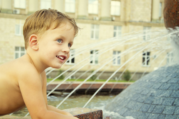 Мальчик возле фонтана в летний день
 - Фото, изображение