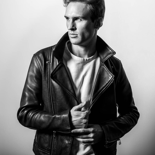 Handsome young man in classic leather jacket. Black-white studio portrait. - Photo, Image