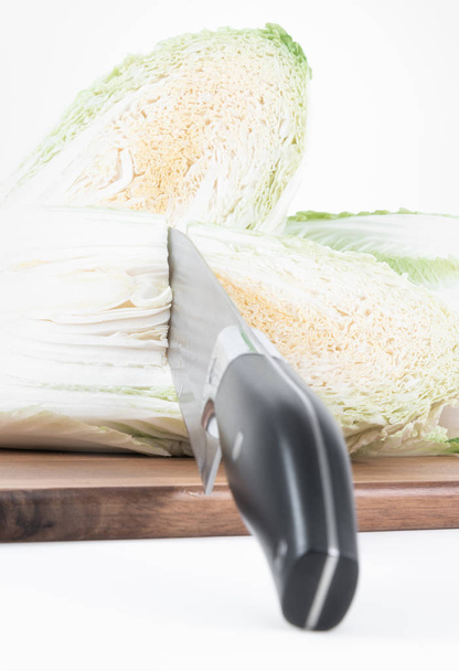 Закрыть двумя половинками китайской капусты и ножом на разделочной доске
 - Фото, изображение