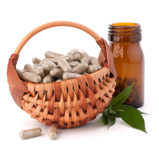 Herbal drug capsules in wicker basket. Alternative medicine conc - 写真・画像