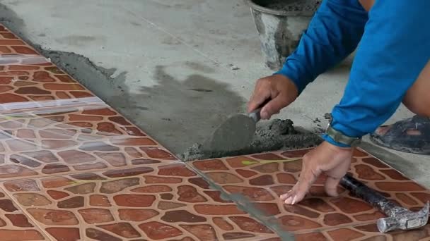 Техники укладывают плитку на пол цементом
. - Кадры, видео
