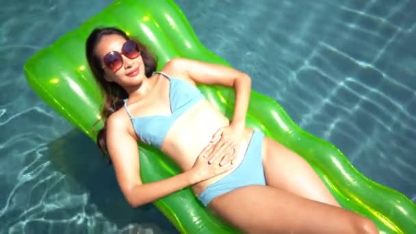 πλάνα της όμορφης Ασιάτισσας χαλαρώνοντας στην πισίνα του ξενοδοχείου - Πλάνα, βίντεο