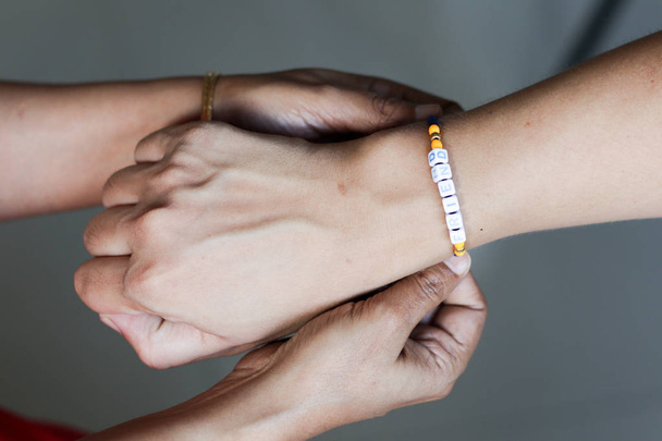 рука женщины, связывающей браслет дружбы в руке парня с избирательным фокусом
 - Фото, изображение