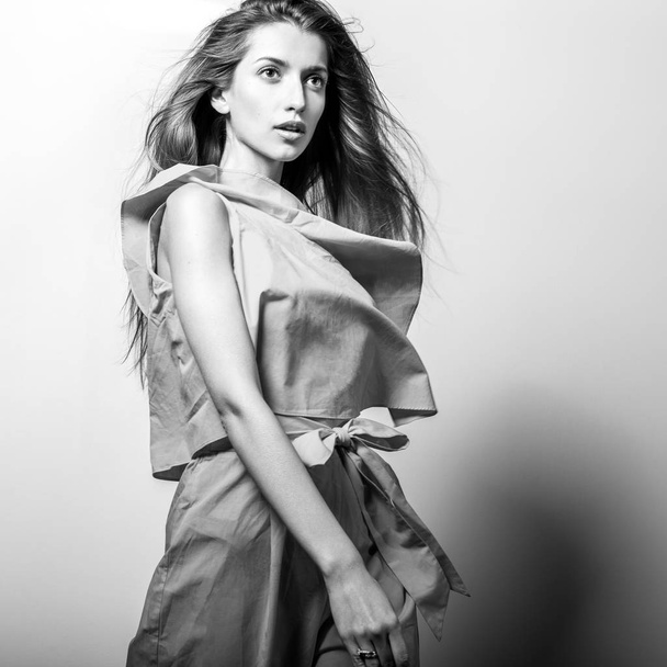 Young model woman in stylish dress pose in studio. Black-white photo. - Φωτογραφία, εικόνα