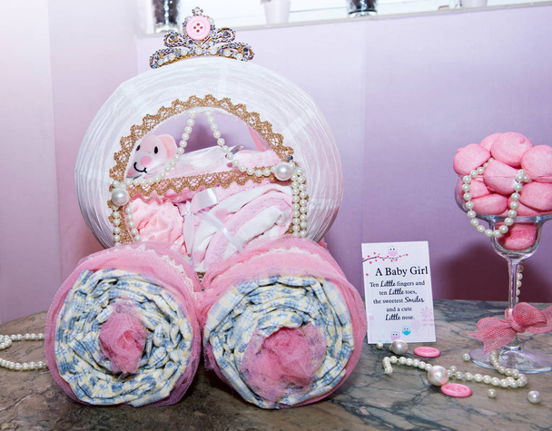 Babyspullen op baby shower party. Het is een meisje, baby meisje. Baby shower avond en meisje items, roze kleding. - Foto, afbeelding