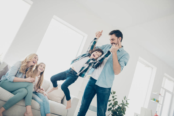 Photo of four members family moving round playful mood play game cozy apartments indoors - Photo, image