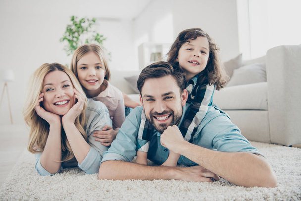 Photo of four members adopted family lying floor toothy smiling fluffy carpet cozy apartments - Foto, Bild