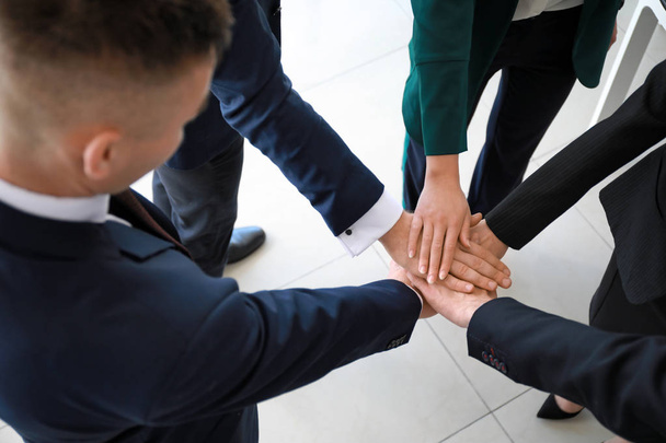 Team of business people putting hands together during meeting in office - Photo, Image