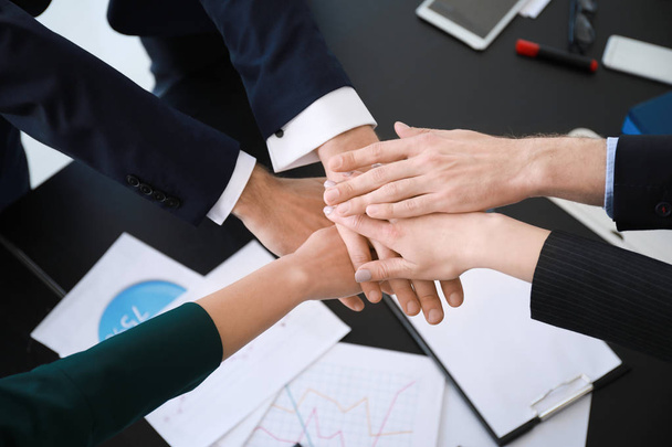 Une équipe de gens d'affaires met la main à la pâte lors d'une réunion au bureau
 - Photo, image