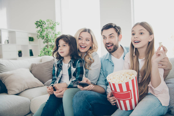 Photo of big family four members spend leisure time by watching tv show sit couch eat salty popcorn - Photo, image
