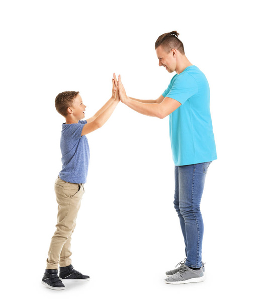 Portrait of father and son giving each other high-five  on white background - Foto, Imagen