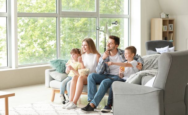 Ευτυχισμένη οικογένεια βλέποντας τηλεόραση στο σπίτι - Φωτογραφία, εικόνα