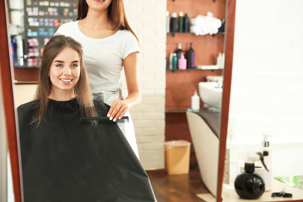 Reflexão de cabeleireiro feminino que trabalha com o cliente no salão
 - Foto, Imagem