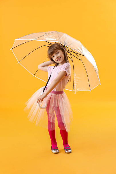 Cute little girl with umbrella on color background - Foto, afbeelding