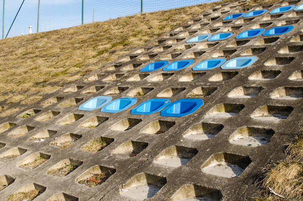 Betonabhang Oberfläche montiert blauen Stühlen ruhen - Foto, Bild