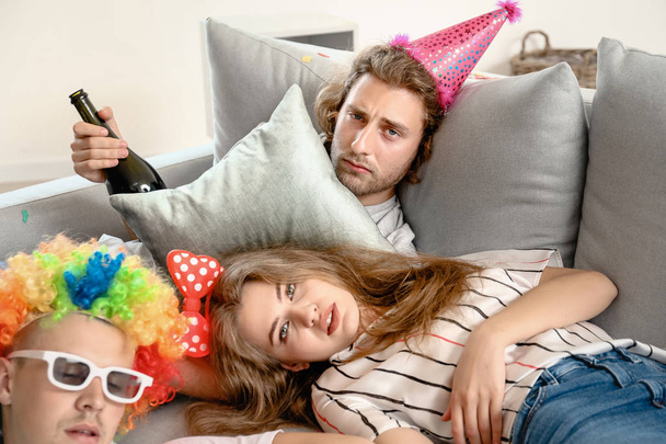 Νέοι άνθρωποι με πονοκέφαλο μετά το πάρτι στο σπίτι - Φωτογραφία, εικόνα