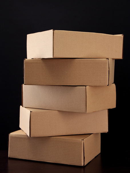 Parcels boxes on wooden table, on black background - Fotografie, Obrázek