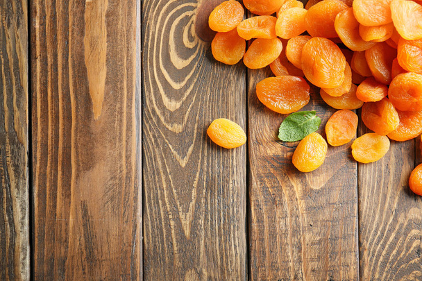 Tasty dried apricots on wooden background - Foto, immagini