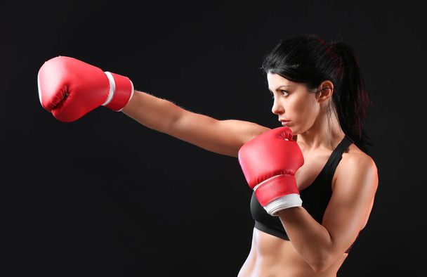 Sporty female boxer on dark background - Фото, зображення
