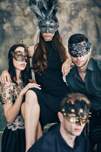 Grupa młodych ludzi w maskarada maski karnawałowe stwarzające w Studio. Koncepcja fotografii mody.                 - Zdjęcie, obraz