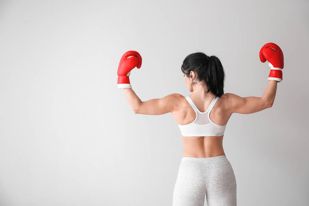 Sporty female boxer on white background - Foto, afbeelding