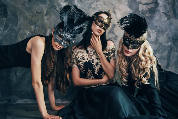 Young women in mysterious venetian masks. Fashion photo concept                      - Foto, afbeelding