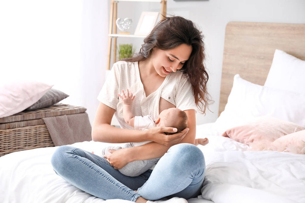 Junge Frau stillt ihr Baby zu Hause - Foto, Bild