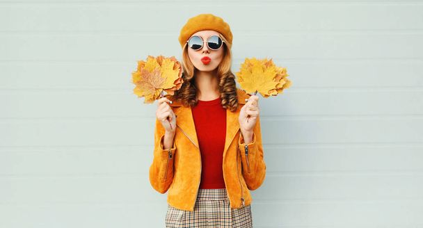 Autumn portrait woman holding yellow maple leaves blowing red li - 写真・画像